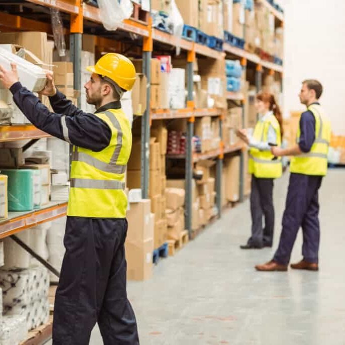 Warehouse worker taking package in the shelf in a large warehouse in a large warehouse